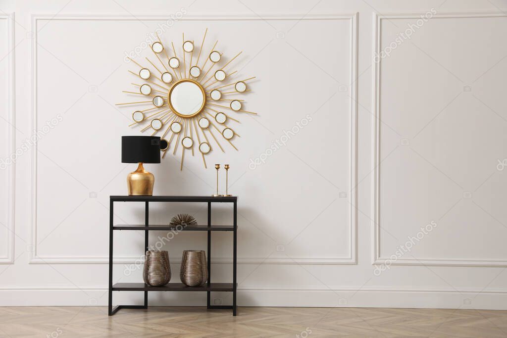 Console table near white wall with mirror in hallway, space for text. Interior design