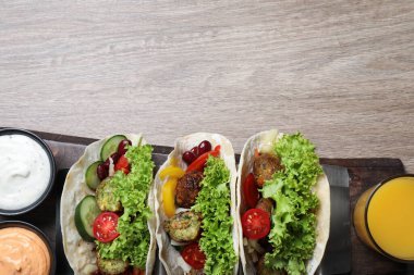 Ahşap masada servis edilen nefis taze vejetaryen tacolar, üst manzara. Metin için boşluk