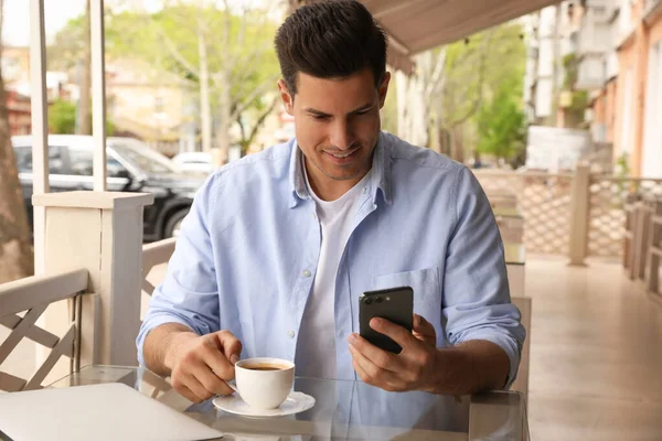 早上在室外咖啡店喝咖啡和智能手机的男人 — 图库照片