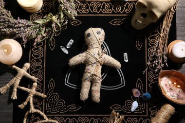 Voodoo doll pierced with pins surrounded by ceremonial items on table, flat lay. Curse ceremony clipart