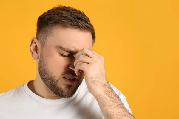 Uomo Che Soffre Emicrania Sfondo Giallo Spazio Testo — Foto Stock