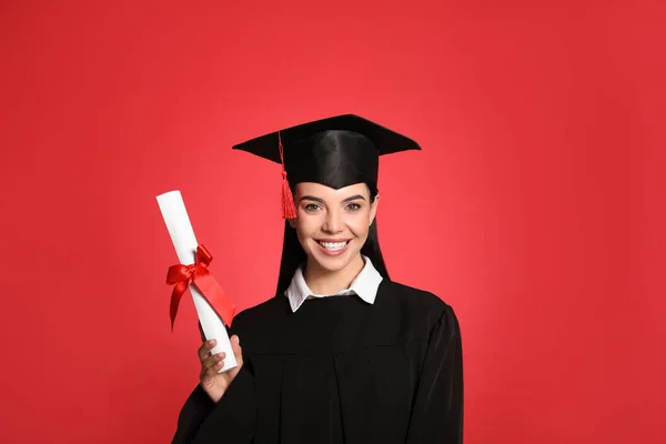 幸せな学生とともに卒業帽子と卒業証書上の赤い背景 — ストック写真