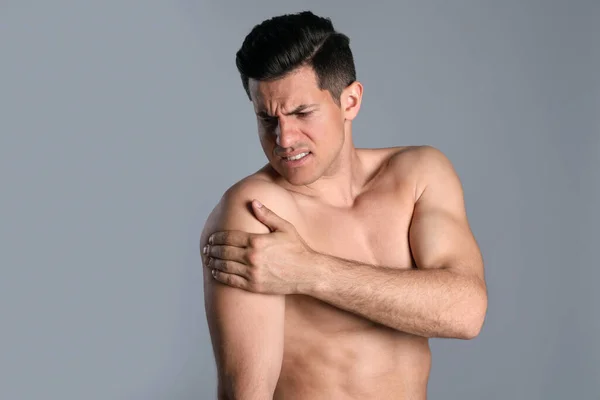 Mann Mit Schulterschmerzen Vor Grauem Hintergrund — Stockfoto