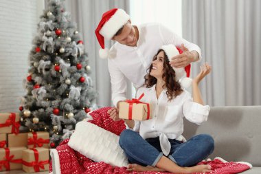 Erkek, kız arkadaşına Noel hediyesi sunar. 