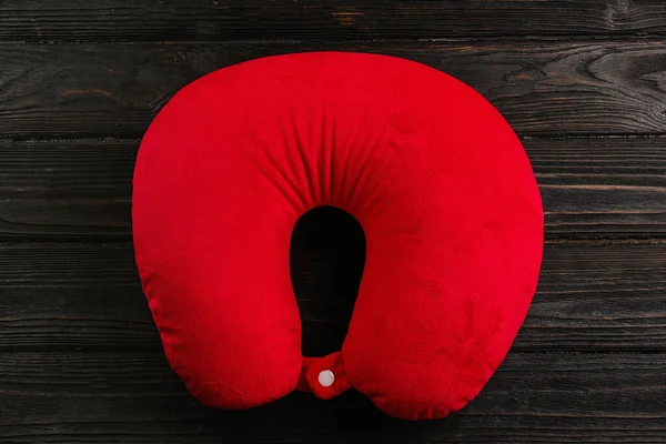 木製の背景に赤い旅行枕 トップビュー — ストック写真