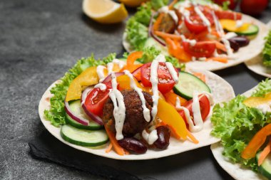 Gri masada servis edilen lezzetli vejetaryen tacolar.