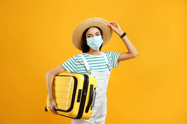 Female Tourist Medical Mask Suitcase Yellow Background Travelling Coronavirus Pandemic — Stock Photo, Image