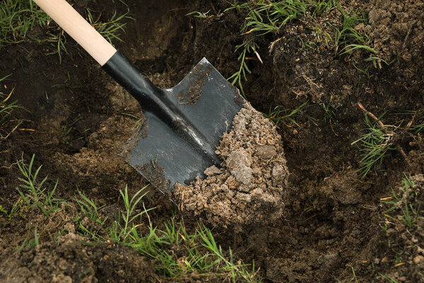 Digging soil with shovel outdoors, closeup. Gardening tool