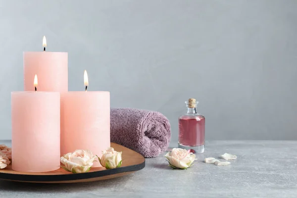 Brennende Kerzen Rosen Ätherisches Und Handtuch Auf Grauem Tisch — Stockfoto