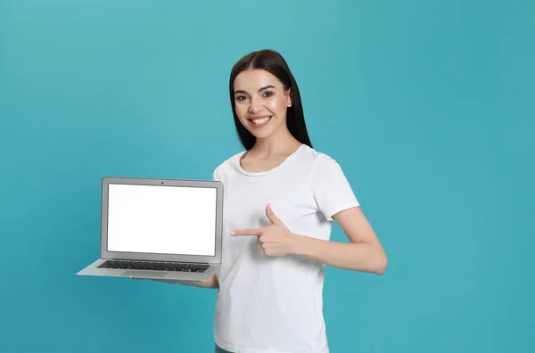 Νεαρή Γυναίκα Δείχνει Σύγχρονο Φορητό Υπολογιστή Λευκή Οθόνη Γαλάζιο Φόντο — Φωτογραφία Αρχείου
