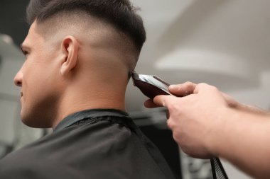 Profesyonel berber kuaförde şık saç kesimi yapıyor, yakın plan.