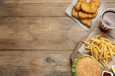 Düz kompozisyon ve ahşap masada lezzetli fast food menüsü. Metin için boşluk