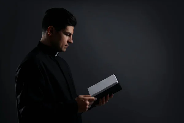 Priester Met Bijbel Zwarte Achtergrond Ruimte Voor Tekst — Stockfoto