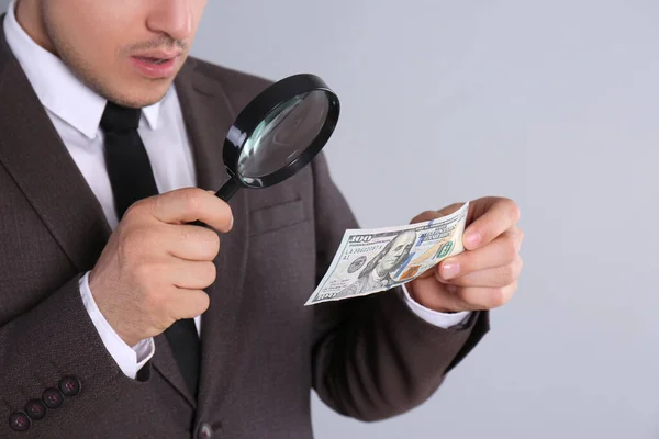 Expert Authenticating 100 Dollar Banknote Magnifying Glass Light Grey Background — Stock Photo, Image