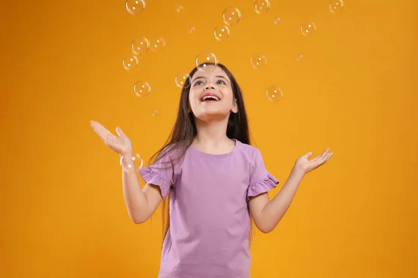 Kleines Mädchen Hat Spaß Mit Seifenblasen Auf Gelbem Hintergrund — Stockfoto
