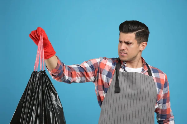 Άντρας Κρατώντας Πλήρη Σακούλα Σκουπιδιών Γαλάζιο Φόντο — Φωτογραφία Αρχείου