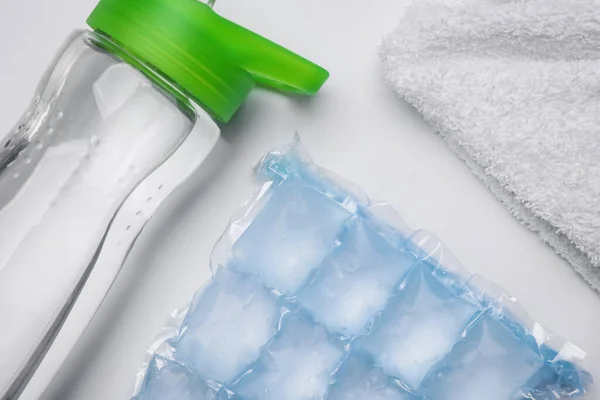 Botella Agua Bolsa Hielo Toalla Sobre Fondo Blanco Puesta Plana —  Fotos de Stock