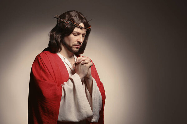 Jesus Christ with crown of thorns praying on beige background, space for text