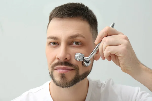 Homem Usando Rolo Facial Metal Fundo Claro — Fotografia de Stock
