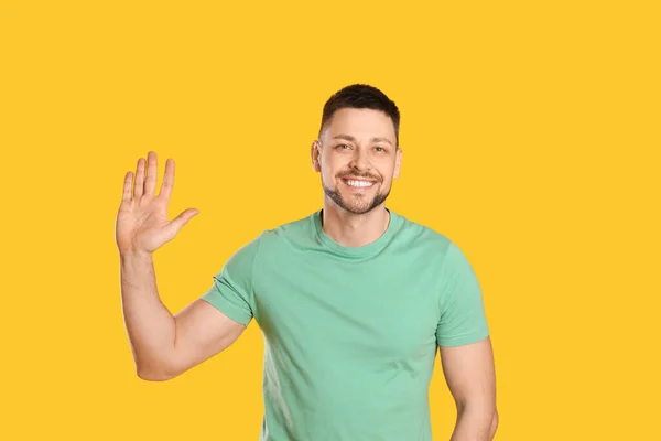 Hombre Alegre Saludando Con Mano Para Saludar Sobre Fondo Amarillo — Foto de Stock