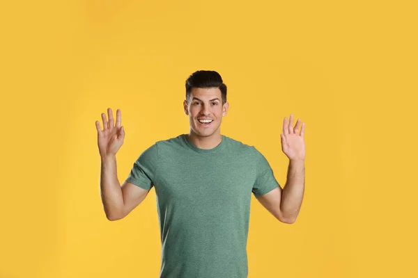 Hombre Alegre Saludando Con Mano Para Saludar Sobre Fondo Amarillo —  Fotos de Stock