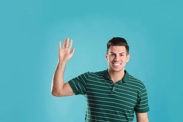 Homem Alegre Acenando Para Dizer Olá Fundo Turquesa — Fotografia de Stock