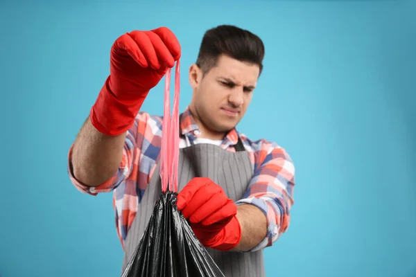 Hombre Sosteniendo Bolsa Basura Llena Contra Fondo Azul Claro Enfoque — Foto de Stock