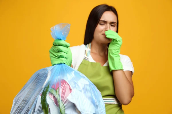 Mulher Segurando Saco Lixo Completo Contra Fundo Amarelo Foco Mão — Fotografia de Stock