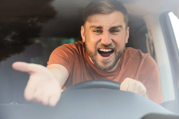 車の中で感情的な男は フロントガラスを介して表示します 積極的な運転行動 — ストック写真