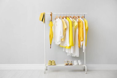 Gri duvarın yanında şık kıyafetler, ayakkabılar ve aksesuarlarla donatın.