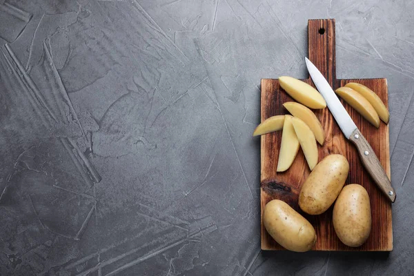 Patatas Crudas Cuchillo Tabla Madera Sobre Mesa Gris Vista Superior — Foto de Stock