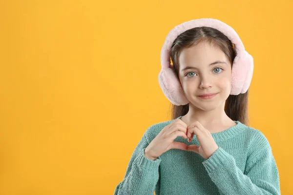 Nettes Mädchen Stylischen Ohrenschützern Macht Herz Mit Händen Auf Gelbem — Stockfoto