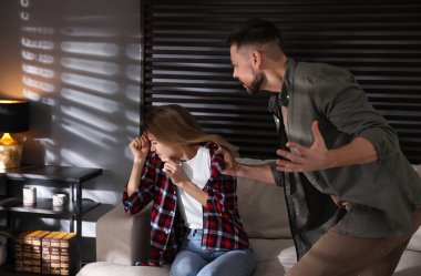 Evinde korkmuş bir kadını taciz eden bir adam. Aile içi şiddet