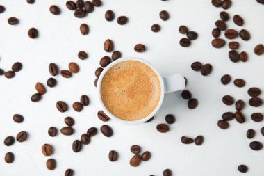 Lezzetli bir espresso ve kahve çekirdekleri beyaz masaya serilmiş, düz yatıyordu.