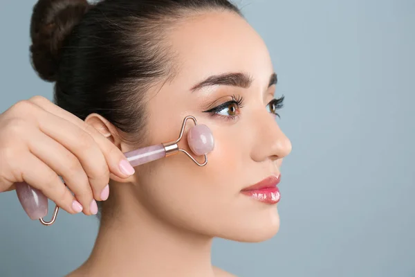 Mujer Usando Rodillo Facial Cuarzo Rosa Natural Sobre Fondo Gris —  Fotos de Stock