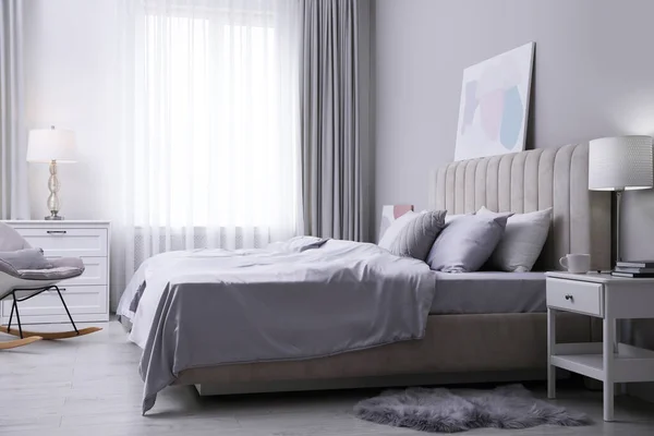 明るい部屋で柔らかい絹のようなベッドルームの服と居心地の良いベッド — ストック写真