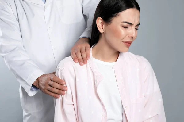 Médecin Examinant Femme Avec Douleur Épaule Sur Fond Gris — Photo