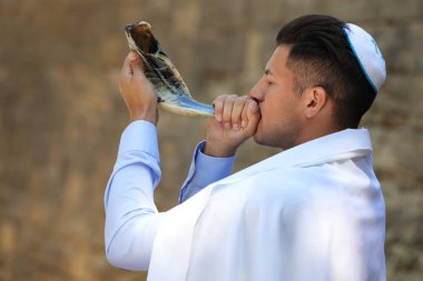 Kippah 'ta Yahudi bir adam ve açık havada Tallit esintisi yapıyor. Rosh Hashanah kutlaması