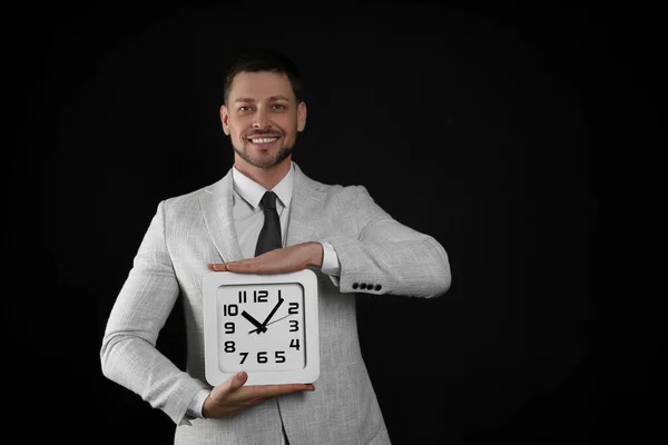 Feliz Hombre Negocios Sosteniendo Reloj Sobre Fondo Negro Espacio Para —  Fotos de Stock