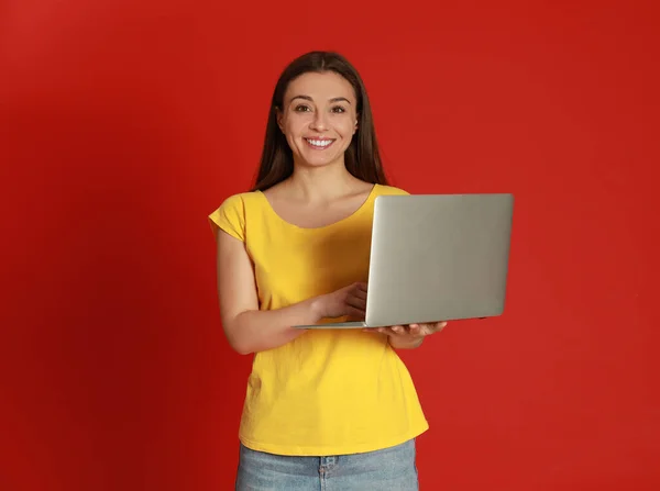 Młoda Kobieta Nowoczesnym Laptopem Czerwonym Tle — Zdjęcie stockowe