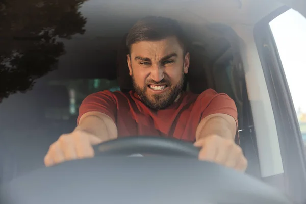 車の中で感情的な男は フロントガラスを介して表示します 積極的な運転行動 — ストック写真