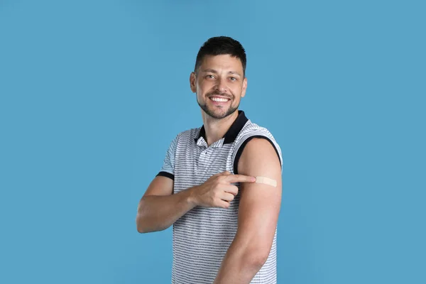 Vaccinated Man Showing Medical Plaster His Arm Light Blue Background — 스톡 사진