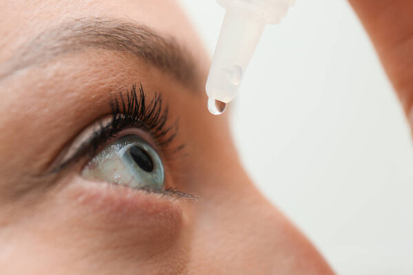 Young woman using eye drops, closeup view