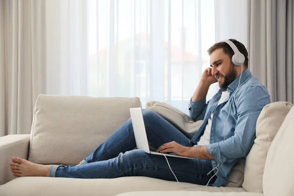 Homem Com Laptop Fones Ouvido Sentado Sofá Casa — Fotografia de Stock