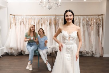 Gelin ve arkadaşları butikte gelinlik seçiyor.