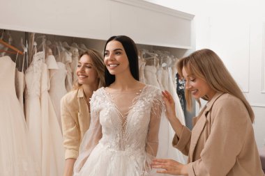 Gelin ve arkadaşları butikte gelinlik seçiyor.