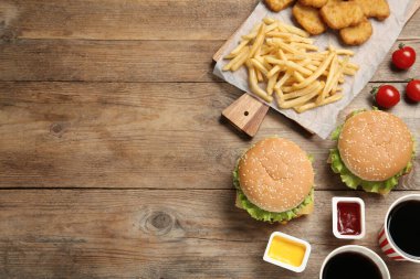 Düz kompozisyon ve ahşap masada lezzetli fast food menüsü. Metin için boşluk