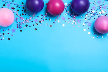 Açık mavi arkaplanda bir sürü balon ve konfeti vardı. Dümdüz uzanıyordu. Doğum günü dekoru