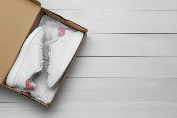 Pair Stylish Sport Shoes Cardboard Box White Wooden Background Top — Stok Foto