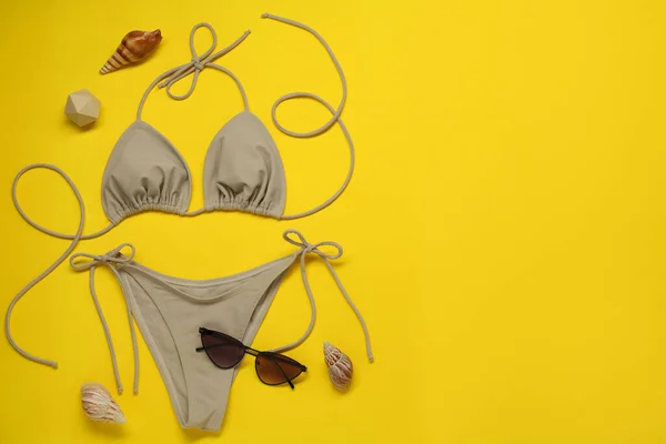 Stijlvolle Beige Bikini Zonnebril Schelpen Gele Achtergrond Vlak Gelegd Ruimte — Stockfoto